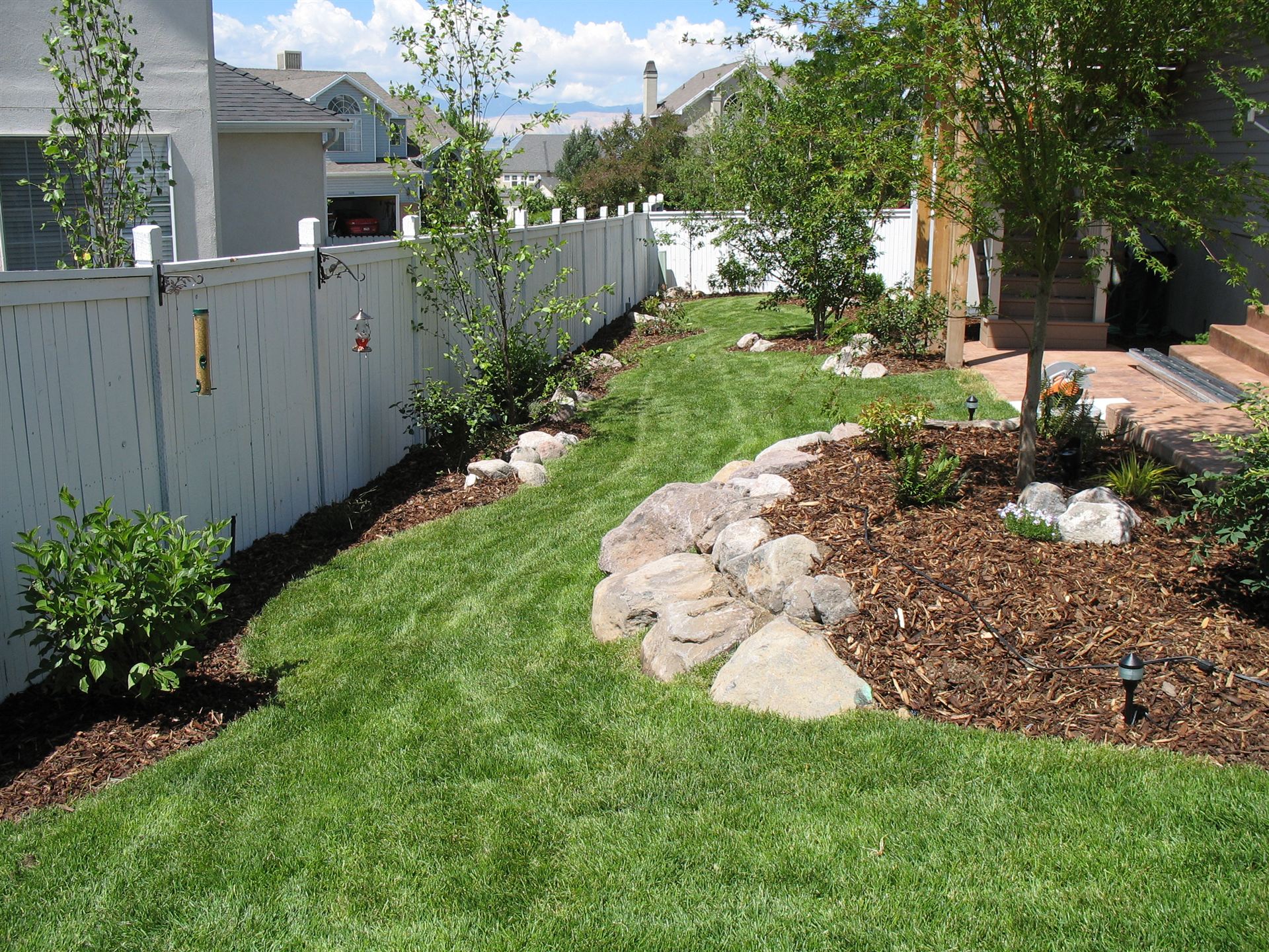 Curved lawn bordered by boulder-edged planting beds