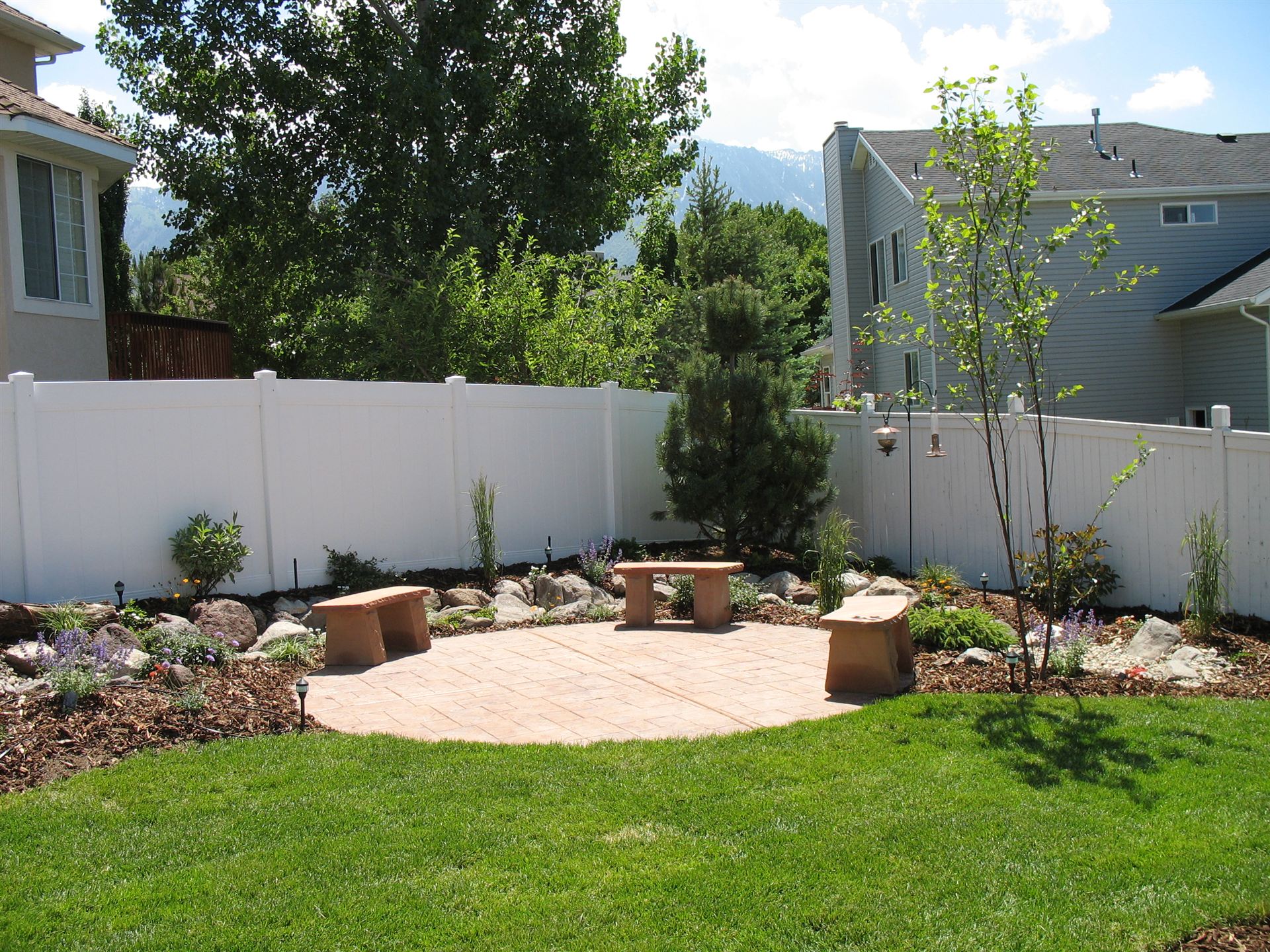 Stamped concrete patio with stone benches and mountain views